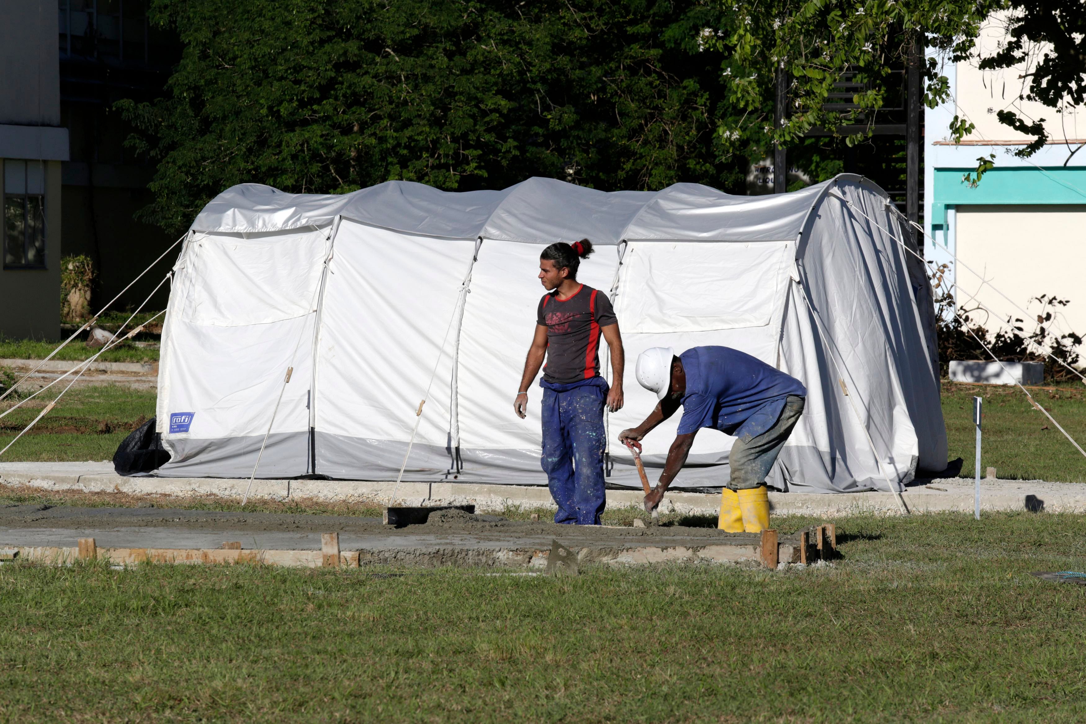 Men work near a tent of a field hospital set up for training purposes, in the Pedro Kouri Tropical Medicine Institute, where Cuban doctors train for their Ebola mission, in Havana October 17, 2014. Photo: Reuters