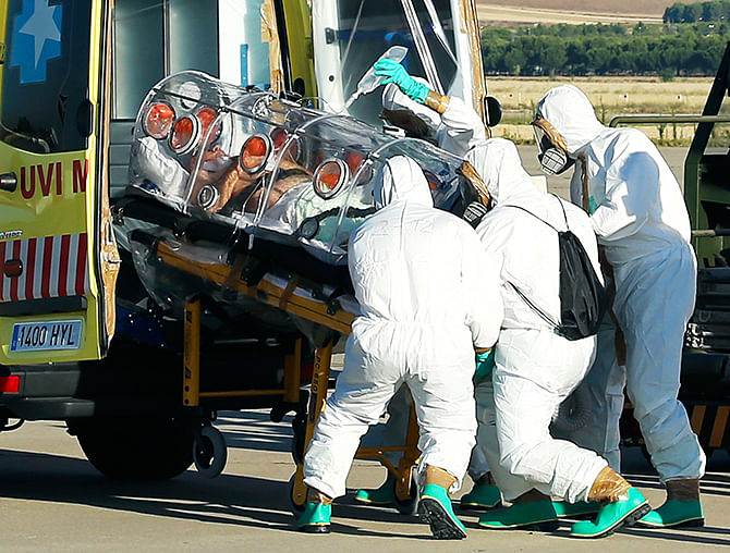 Health workers load an Ebola patient into an ambulance on the tarmac of Torrejon airbase in Madrid, after he was repatriated from Liberia for treatment in Spain, August 7, 2014. Photo: Reuters