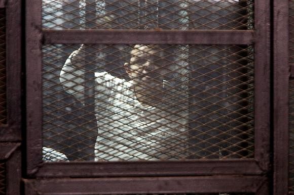 A Muslim Brotherhood supporter convicted of playing a role in the killings of 16 policemen in August 2013 during the upheaval that followed the army's ouster of Islamist president Mohamed Morsi, stands behind bars during their trial in Cairo, February 2, 2015. Photo: Reuters
