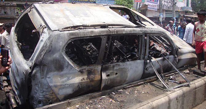 The burnt car of Phulgazi upazila chairman lies on a road in Academy area of Feni town after miscreants set fire to it on May 20, leaving the chairman dead on the spot. Photo: Star