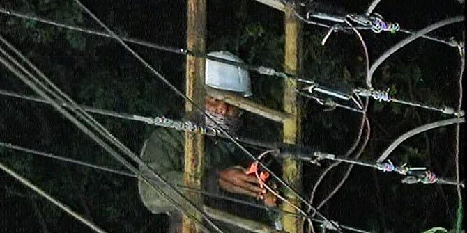 A member of Desco cuts the power line to BNP Chairperson Khaleda Zia’s Gulshan office in Dhaka on early Saturday. Photo: TV grab 