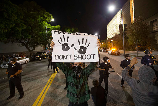 A protester holds a sign during a march in Los Angeles, California, following Monday's grand jury decision in the shooting of Michael Brown in Ferguson, Missouri, November 25, 2014. Photo: Reuters