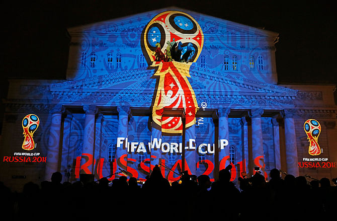 Journalists look at a light installation showing the official logotype of the 2018 FIFA World Cup during its unveiling ceremony at the Bolshoi Theater building in Moscow, October 28, 2014. Photo: Reuters