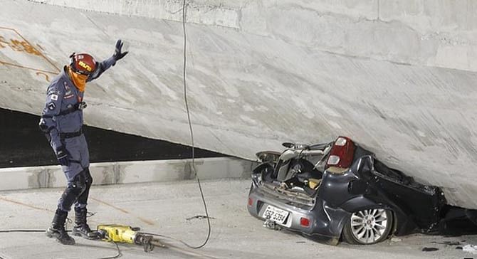 This AP photo shows a car has been crushed when the flyover collapsed in Belo Horizonte, host city of World Cup 2014 in Brazil on July 4, 2014.
