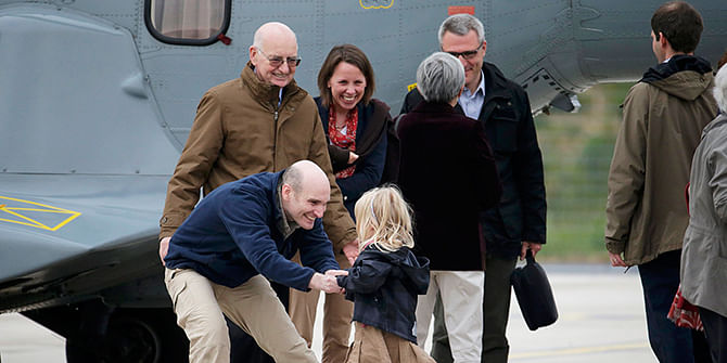 Nicolas Henin (L), former French hostage and journalist, is greeted by his family moments after the arrival of the ex-hostages by helicopter from Evreux to the military airbase in Villacoulbay, near Paris, April 20, 2014. Photo Reuters
