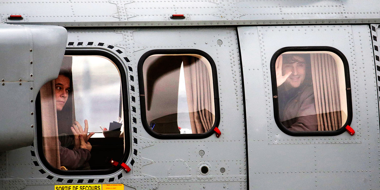 Former French hostages and journalists Didier Francois (L) and Edouard Elias (R), who waves, look toward awaiting media from inside their helicopter at their arrival to the military airbase in Villacoulbay, near Paris. Photo: Reuters 