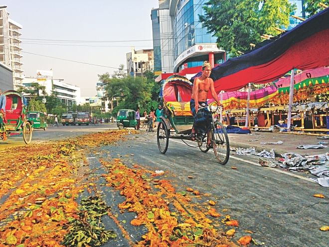 This Star photo taken on June 14 shows crushed mangoes remain on the Mirpur Road at Kalabagan in the capital after a mobile court destroyed the chemical-tainted mangoes by running them over with a truck in the afternoon. Roadside shops there, on the right, were selling the mangoes, claiming them to be chemical-free. Photo: Pinaki Roy