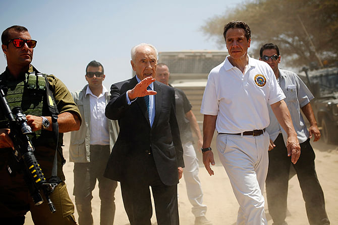 Former Israeli President Shimon Peres (C) and New York Governor Andrew Cuomo (R) walk together during a tour to see a tunnel exposed by the Israeli military on the Israeli side of the Israel-Gaza border August 14, 2014.  Photo: Reuters