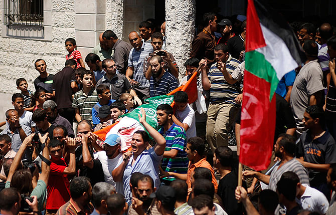Mourners chant slogans during the funeral of the wife of Hamas's military leader, Mohammed Deif, his infant son Ali and other Palestinians whom medics said were killed in Israeli air strikes, in the northern Gaza Strip August 20, 2014. Photo: Reuters