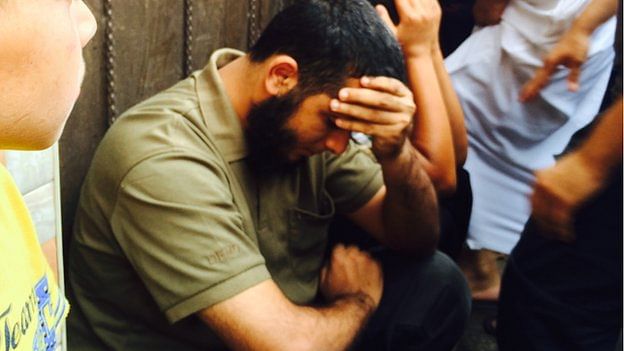 The brother of Hamas fighter Nidal al-Malesh sitting in shock not long after his brother was killed in an Israeli missile strike. The photo is taken from BBC Online. 