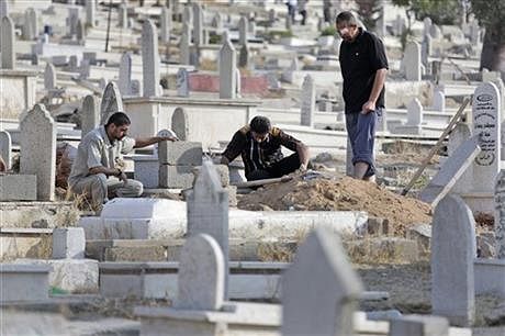 Relatives pause as they prepare the grave for their loved one, who died of natural causes, at a cemetery in Gaza City, in the northern Gaza Strip, Monday, July 28. Photo: AP