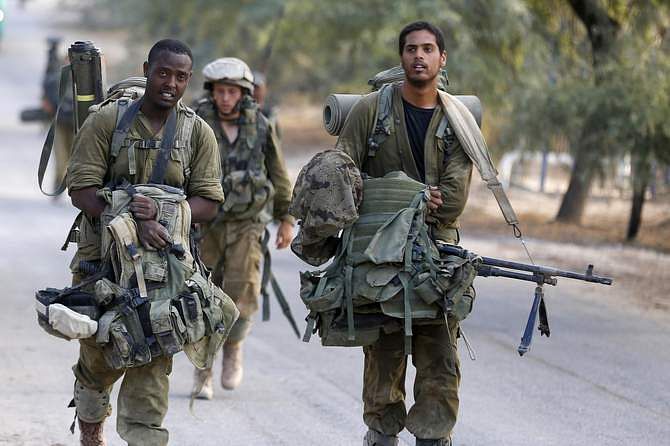An Israeli soldier from the Nahal Brigade carry equipment after returning to Israel from Gaza August 5, 2014. Israel pulled its ground forces out of the Gaza Strip on Tuesday and started a 72-hour ceasefire with Hamas mediated by Egypt as a first step towards negotiations on a more enduring end to the month-old war. Photo: Reuters