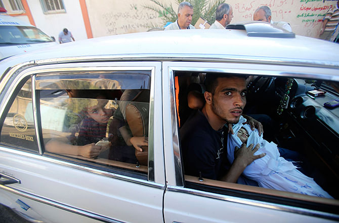 A relative sits in a car as he carries the body of two-and-a-half-year-old Palestinian girl Raghad Massoud, whom medics said was killed in an Israeli air strike, before her burial in Rafah in the southern Gaza Strip August 4, 2014. Israel said it would unilaterally hold fire in most of the Gaza Strip on Monday to facilitate the entry of humanitarian aid and allow some of the hundreds of thousands of Palestinians displaced by an almost four-week-old war to go home. Photo: Reuters