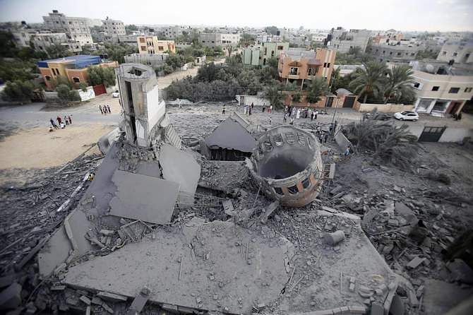 Palestinians gather around the remains of a mosque, which witnesses said was destroyed in an Israeli air strike before a 72-hour truce, in Khan Younis in the southern Gaza Strip August 11, 2014. Photo: Reuters
