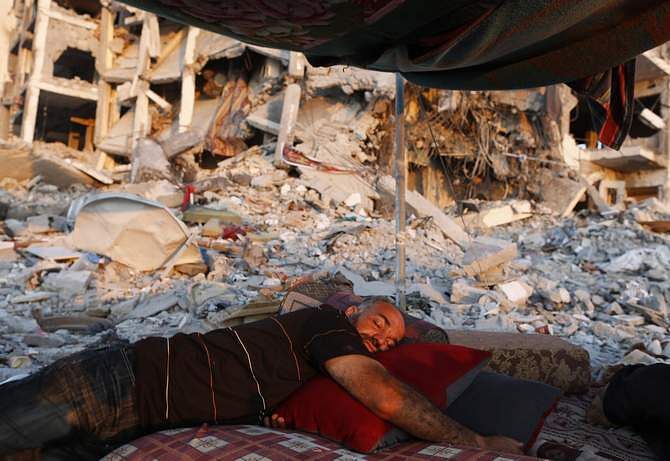 A Palestinian man sleeps in a tent outside his apartment, which witnesses said was destroyed in an Israeli offensive, during a 72-hour truce in Beit Lahiya town in the northern Gaza Strip August 11, 2014. Photo: Reuters