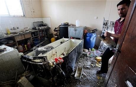 Palestinian inspects a ruble of a destroyed house of Qasim Alwan, 4, Imad Alwan, 6, after it was hit by an Israeli tank shell on Friday in Gaza City, Saturday, July 19. Photo: AP