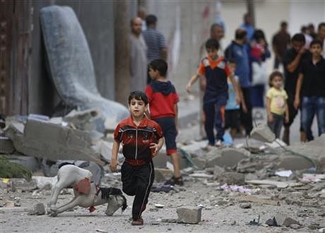 A Palestinian child runs on debris from a destroyed house, following an overnight Israeli strike in Beit Lahiya, in northern Gaza strip, Saturday. Photo: AP