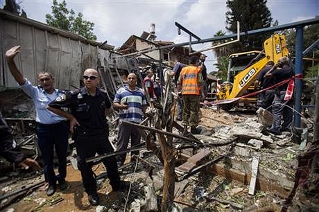 In this Tuesday, July 22, 2014, file photo, Israeli police officers secure a destroyed house that was hit by a rocket fired by Palestinians militants from Gaza, in Yahud, a Tel Aviv suburb near the airport, central Israel. Photo: AP