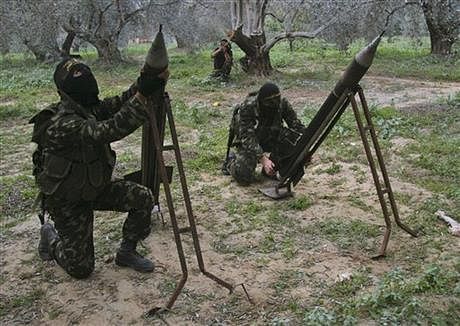  In this Dec. 20, 2008, file photo, masked Palestinian militants from Islamic Jihad place homemade rockets before later firing them into Israel on the outskirts of Gaza City. Photo: AP