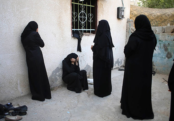 Relatives of Palestinian woman Amani Baraka, whom medics said was killed in an Israeli air strike, mourn during her funeral in Khan Younis in the southern Gaza Strip August 10, 2014. Photo: Reuters