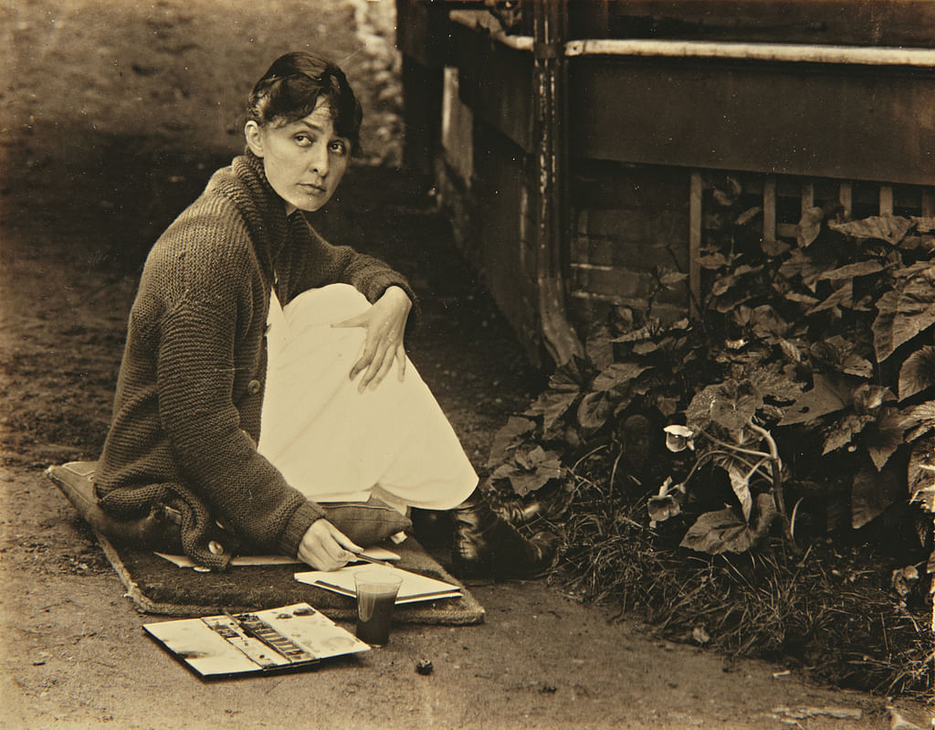 Alfred Stieglitz photograph of O'Keeffe with sketchpad and watercolors, 1918. 
