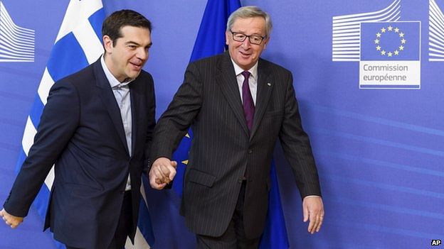 Jean-Claude Juncker (right) walks hand in hand with Alexis Tsipras as the Greek PM arrives at the European Commission. Photo: AP
