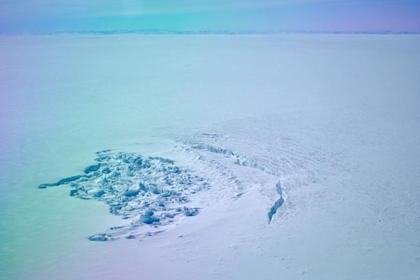 The crater left behind by the sub-glacial lake, as well as a deep crack in the ice. The photo is taken from natureworldnews.com. 