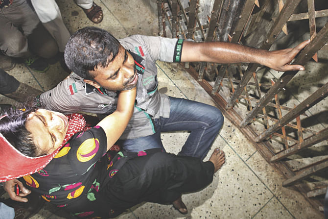 This Star photo taken on August 28, 2014 shows relatives of the murdered victims at Sonalibagh burst into tears in front of the DMCH room where the bodies were kept in the night.