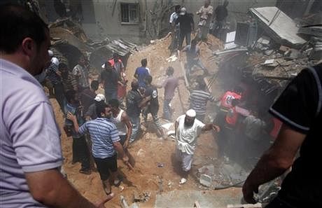 Palestinians search for survivors under the rubble of a house destroyed by an Israeli missile strike, in Gaza City, Monday. Photo: AP