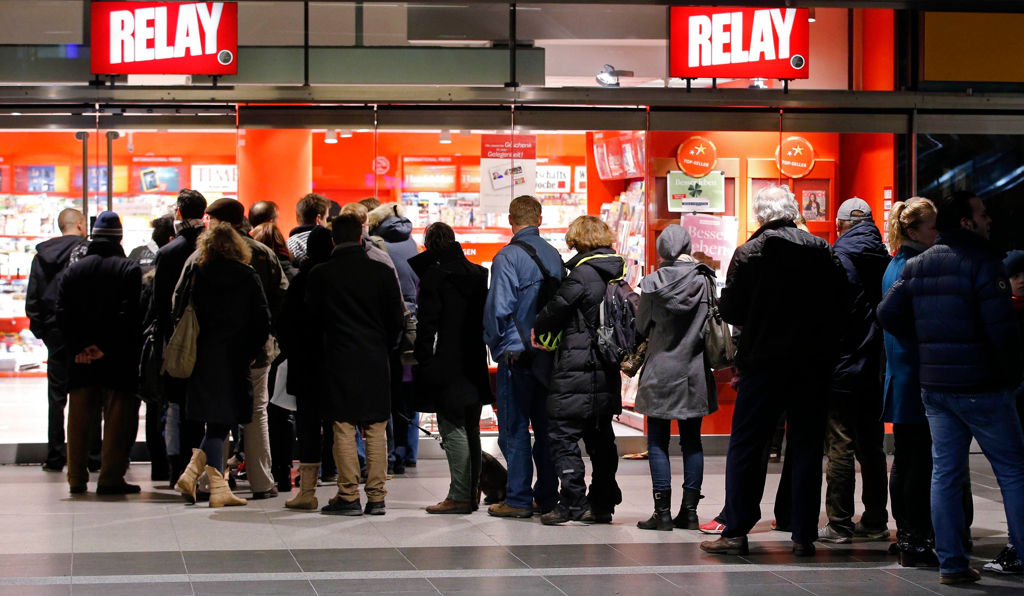 Customers queue outside a newsagent's and bookstore to buy copies of the first edition of French satirical weekly magazine Charlie Hebdo published after the deadly attacks by Islamist gunmen in Paris last week, at the main Hauptbahnhof railway station in Berlin January 17. Photo: Reuters 