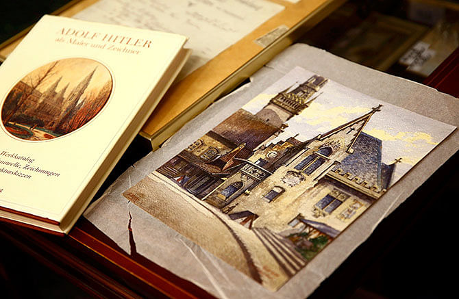 A watercolour of the old registry office in Munich by former German dictator Adolf Hitler lies next to a catalog of his paintings and drawings at Weidler auction house in Nuremberg November 18. Photo: Reuters
