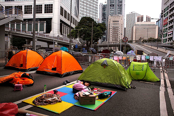 Pro-democracy protesters sleep on a road blocked with tents and fences at the financial Central district in Hong Kong October 10, 2014. Photo: Reuters