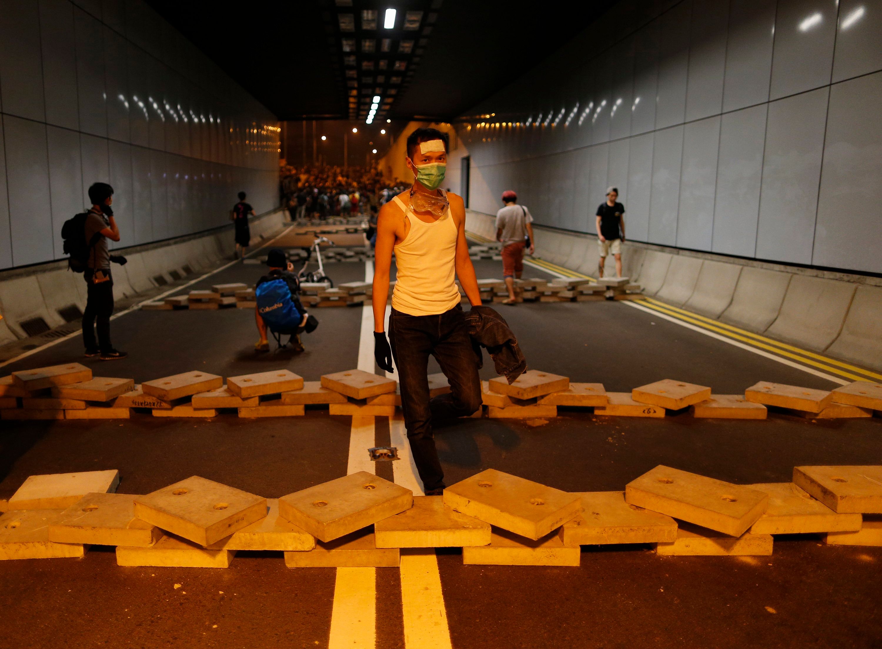 A pro-democracy protester walks in between bricks inside a vehicle tunnel to block traffic leading to the financial Central district near the government headquarters in Hong Kong early October 15. Photo: Reuters