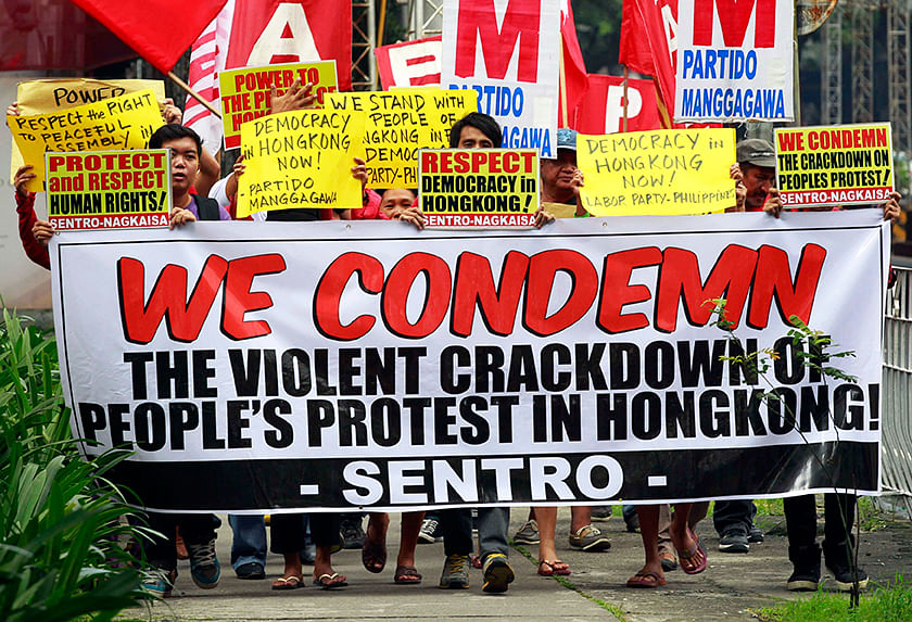 Activists display a banner and placards as they march towards the Chinese embassy during a demonstration in support of Hong Kong pro-democracy protesters, in Makati city, metro Manila October 3, 2014. Photo: Reuters