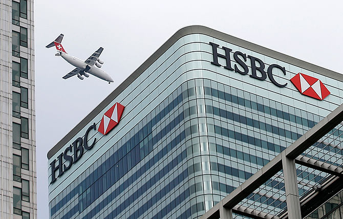 A Swiss International aircraft flies past the HSBC headquarters building in the Canary Wharf financial district in east London February 15, 2015. Photo: Reuters