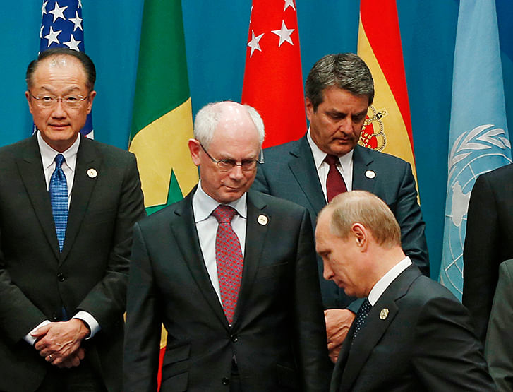 Russian President Vladimir Putin (front) looks for his standing position near European Council President Herman Van Rompuy (2nd L) during a group photo of G20 leaders and representatives of partner groups at the G20 summit venue in Brisbane November 15, 2014. Photo: Reuters