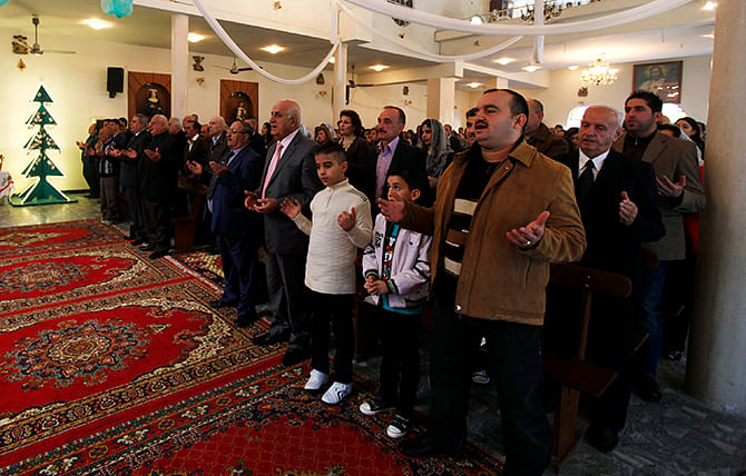 Iraqi Christians attend a mass at Sacred Heart Catholic Church in Baghdad December 25, 2014. The pews filled at Baghdad's Sacred Heart church, as people remembered the darkest year in memory. Photo: Reuters
