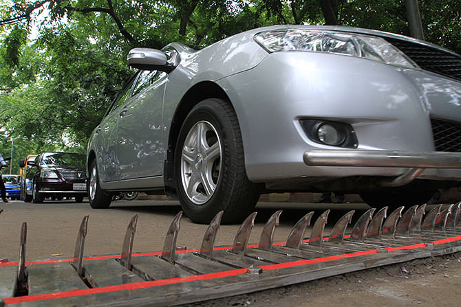 A car can be seen passing over the spikes. The spikes retract back to the roads if a car approaches from the right direction. Photo: Palash Khan