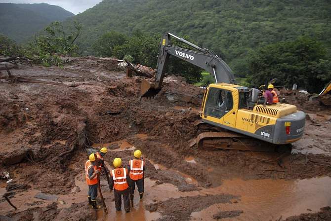 National Disaster Response Force (NDRF) personnel clear the debris from the site of a landslide at Malin village, in the western Indian state of Maharashtra July 30, 2014. Photo: Reuters