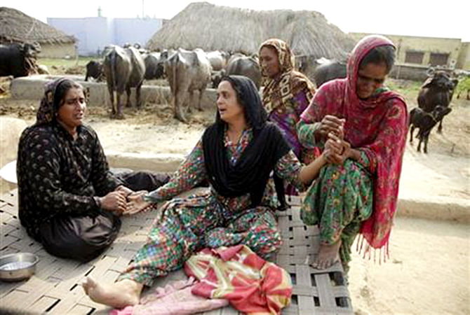 Relatives of Akram Hussain, a civilian killed in gunfire allegedly from the Pakistan side of the border, weep at their village in Ranbir Singh Pura region, about 35 kilometers (22 miles) from Jammu, India, Saturday, Aug 23, 2014. Photo: AP