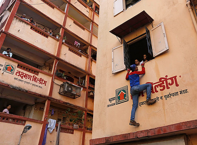 Gaurav Sharma, an independent candidate also known as the Indian Spider-Man, climbs a residential building during an election campaign in Mumbai on Friday. Photo: Reuters