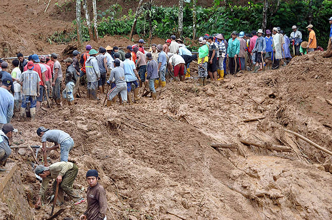 Villagers use shovels to remove mud from the main road at Pasuruhan village in Wonosobo December 12, 2014, in this photo taken by Antara Foto. Heavy rain caused a landslide early Friday in Pasuruhan village, with a citizen killed when a 50-meter high cliff hit the road. Picture taken December 12, 2014. Photo: Reuters
