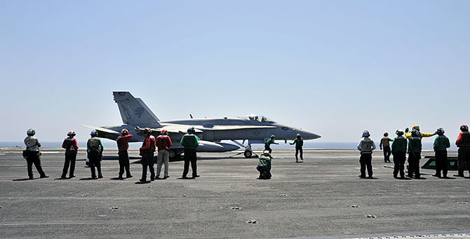 Sailors make final inspections on an F/A-18C Hornet assigned to the Golden Warriors of Strike Fighter Squadron (VFA) 87 aboard the aircraft carrier USS George HW Bush (CVN 77) in the Gulf, in this August 7, 2014 handout image released on August 8. Photo: Reuters