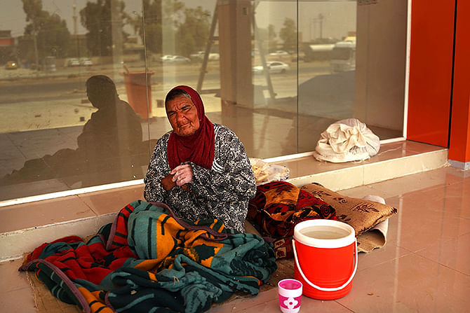 An Iraqi woman rests on the floor of an empty store at a construction site where she is living with dozens of other displaced Iraqis who have fled the fighting in and around the city of Mosul on June 29, 2014 in Kalak, Iraq. Photo: Getty Images
