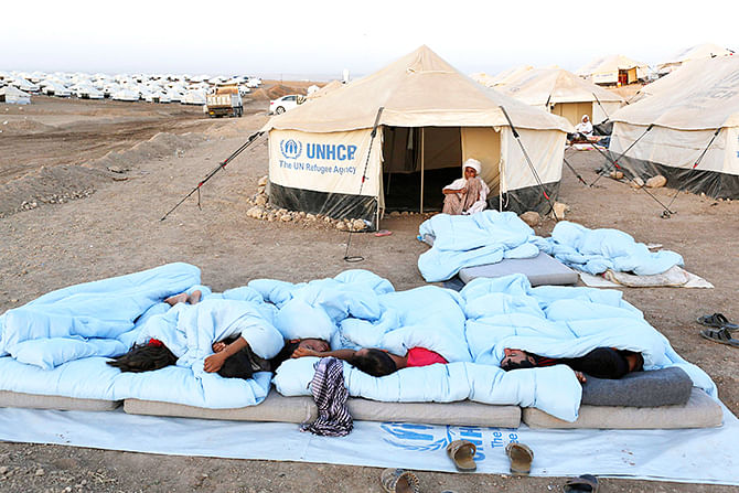 Displaced people from the minority Yazidi sect, who fled violence in the Iraqi town of Sinjar, sleep on the ground at Bajed Kadal refugee camp, southwest of Dohuk province, August 23, 2014. Photo: Reuters