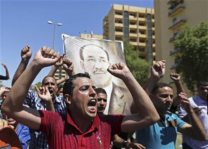  Iraqis chant pro-government slogans and display placards bearing a picture of embattled Prime Minister Nouri al-Maliki during a demonstration in Baghdad, Iraq, Monday, Aug. 11, 2014. Photo:AP