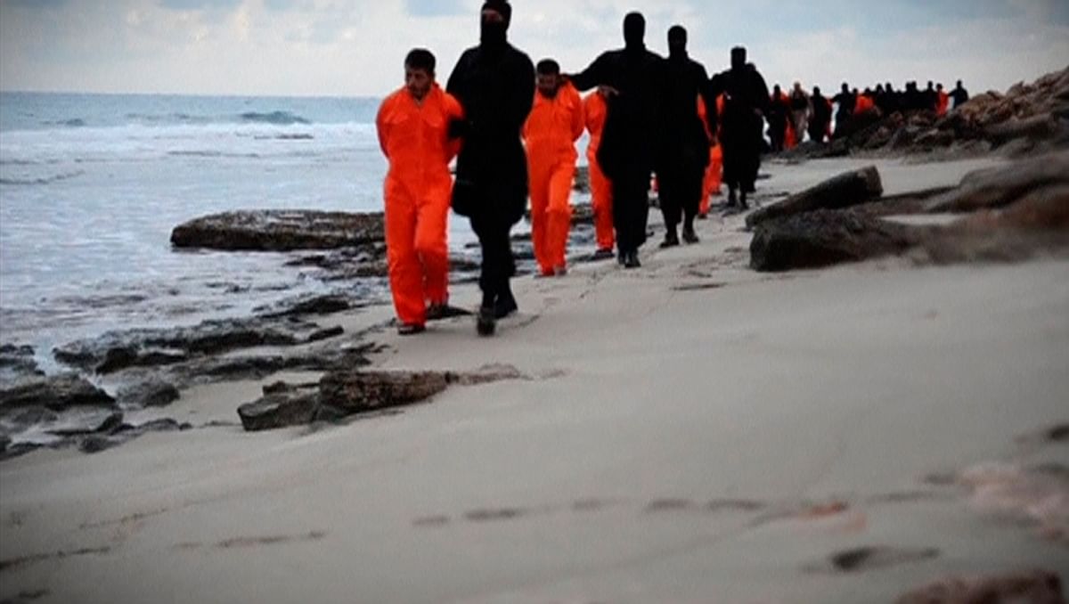 Men in orange jumpsuits purported to be Egyptian Christians held captive by the Islamic State (IS) are marched by armed men along a beach said to be near Tripoli, in this still image from an undated video made available on social media on February 15, 2015. Photo: Reuters