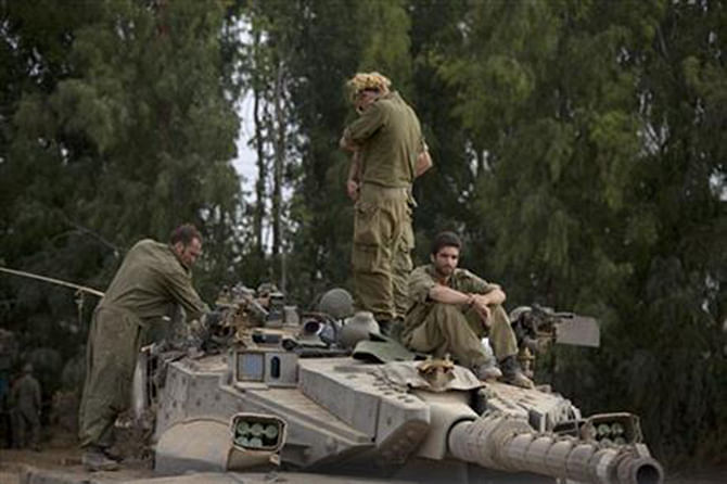 Israeli soldiers work on a tank near the Israel and Gaza border Thursday, July 24, 2014.Photo: AP