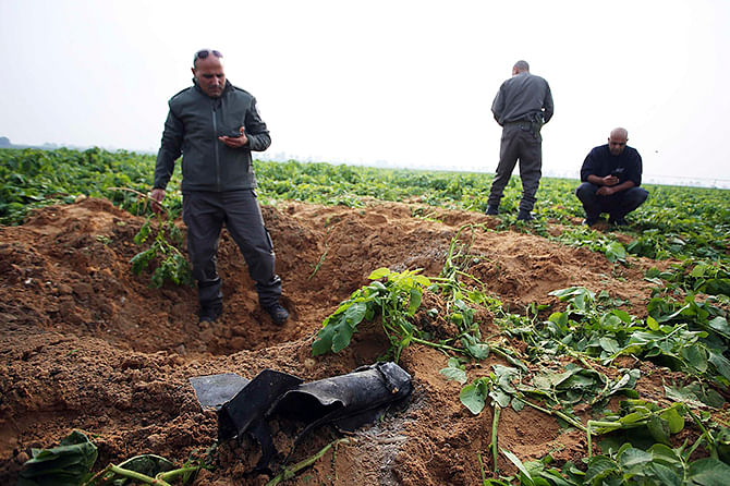 Israeli security forces stand next to the remains of a rocket that was fired from the Gaza Strip towards Israel on Friday, on the Israeli side of the border December 19, 2014. Photo: Reuters