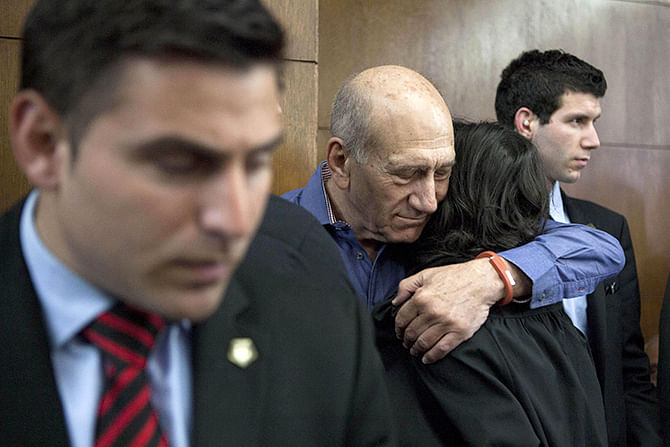 This Reuters photo taken on March 31, 2014 shows former Israeli Prime Minister Ehud Olmert (2nd L) hugs a woman while waiting to hear his verdict at the Tel Aviv District Court.
